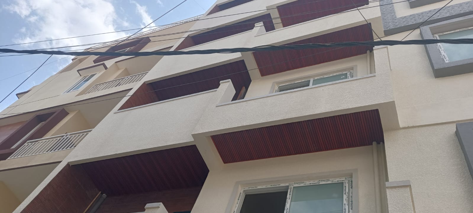 Apartment building facade with wooden louvre cladding panels above the windows
