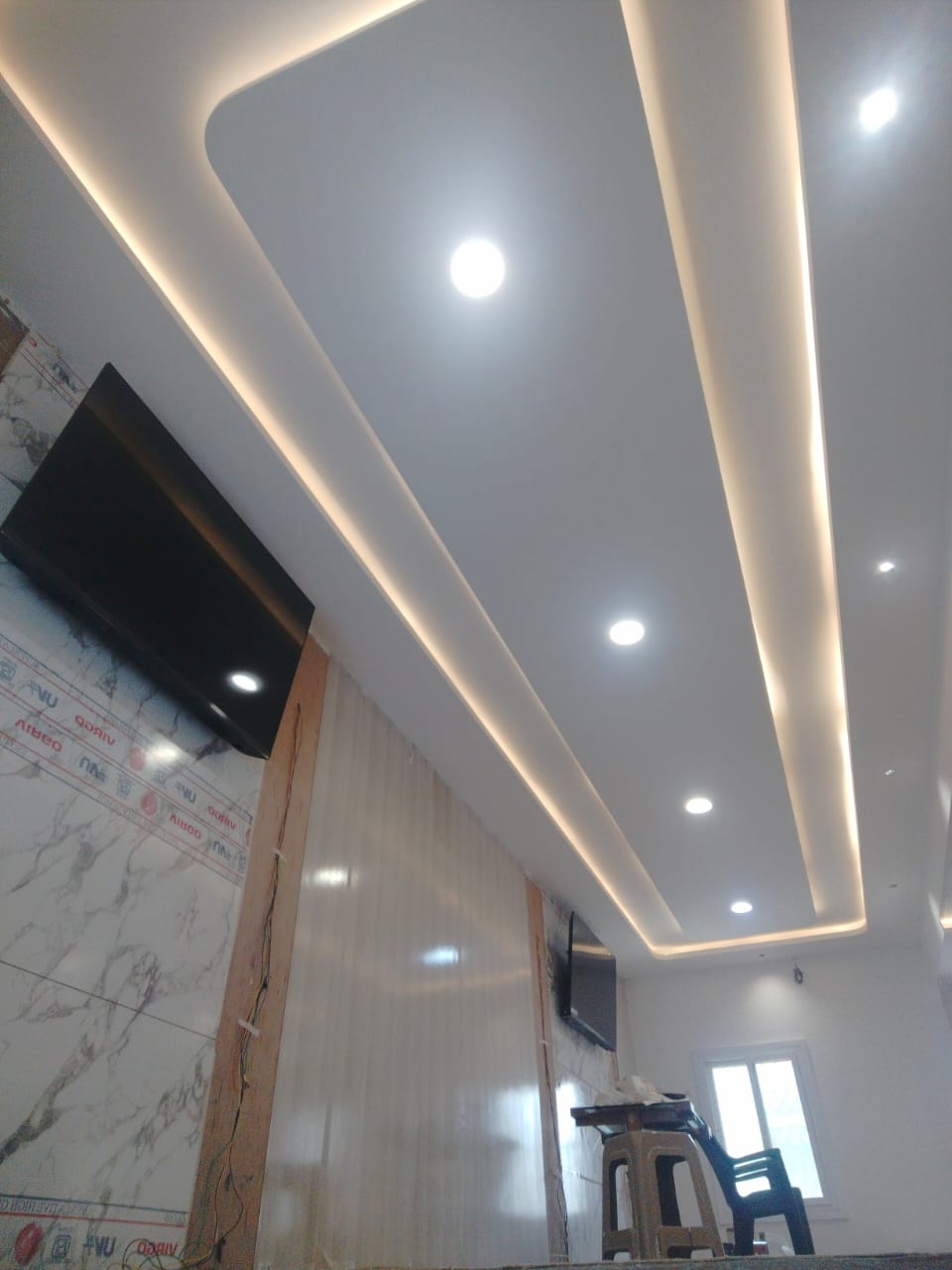 Layered gypsum ceiling design with continuous cove lighting and downlights